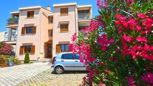 A multi-story residential building with a car parked in front. - Elegant and Brigth Corner Apartments (Rovinj)