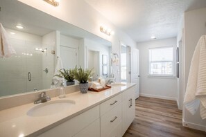 A modern bathroom with a large mirror, two sinks, and a potted plant. - Modern Home | Near American Fork Canyon (American Fork)