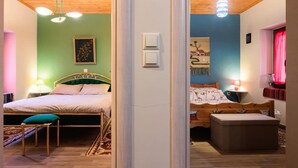 Een slaapkamer met een bed, nachtkastje, lamp en een raam met gordijnen.