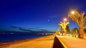 A nighttime beach scene with a clear sky, a visible moon, and street lamps along the walkway. - Uncover Kalamata s Hidden Gem - Cosy City Nest (Kalamata)