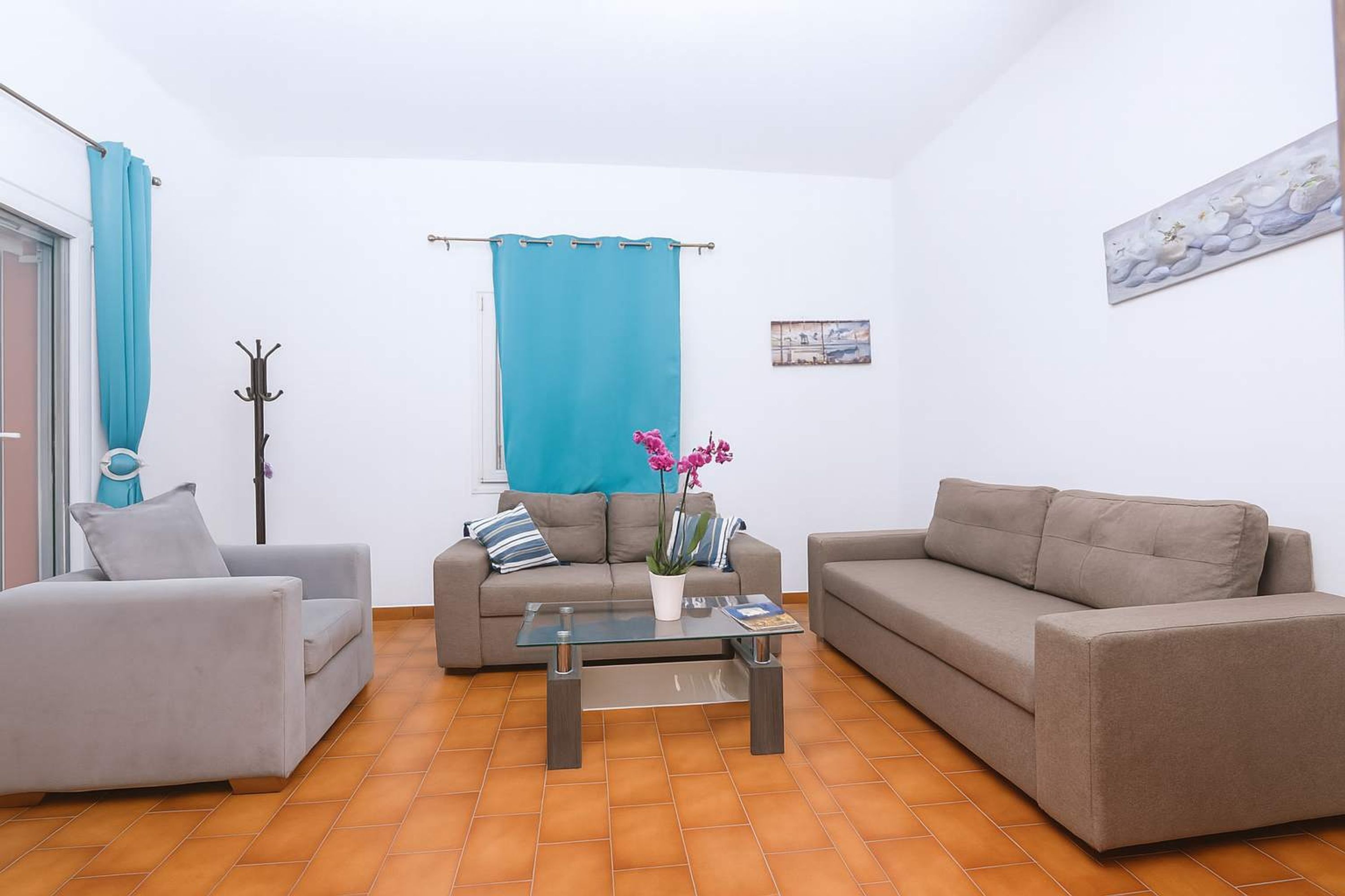 A living room with two sofas, a coffee table, and a blue curtain.