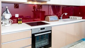 Une cuisine moderne équipée d’un four encastré, d’une machine à café et d’un four à micro-ondes.
