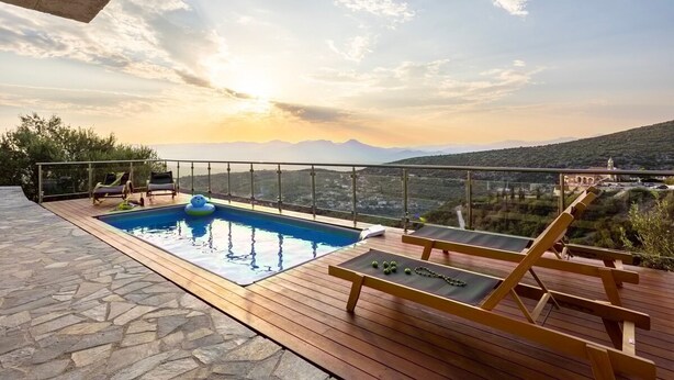 A rooftop pool with wooden deck and lounge chairs, overlooking a mountainous landscape. - Martinia Pool Escape - Tragos Panoramic Views (Kalamata)