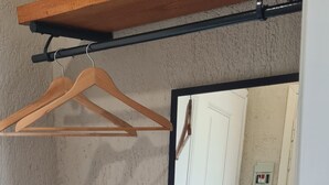 A room with a wooden shelf, a mirror, and a door. - Persephone Seaview Room - Ariadne Skopelos Getaway (Skopelos)