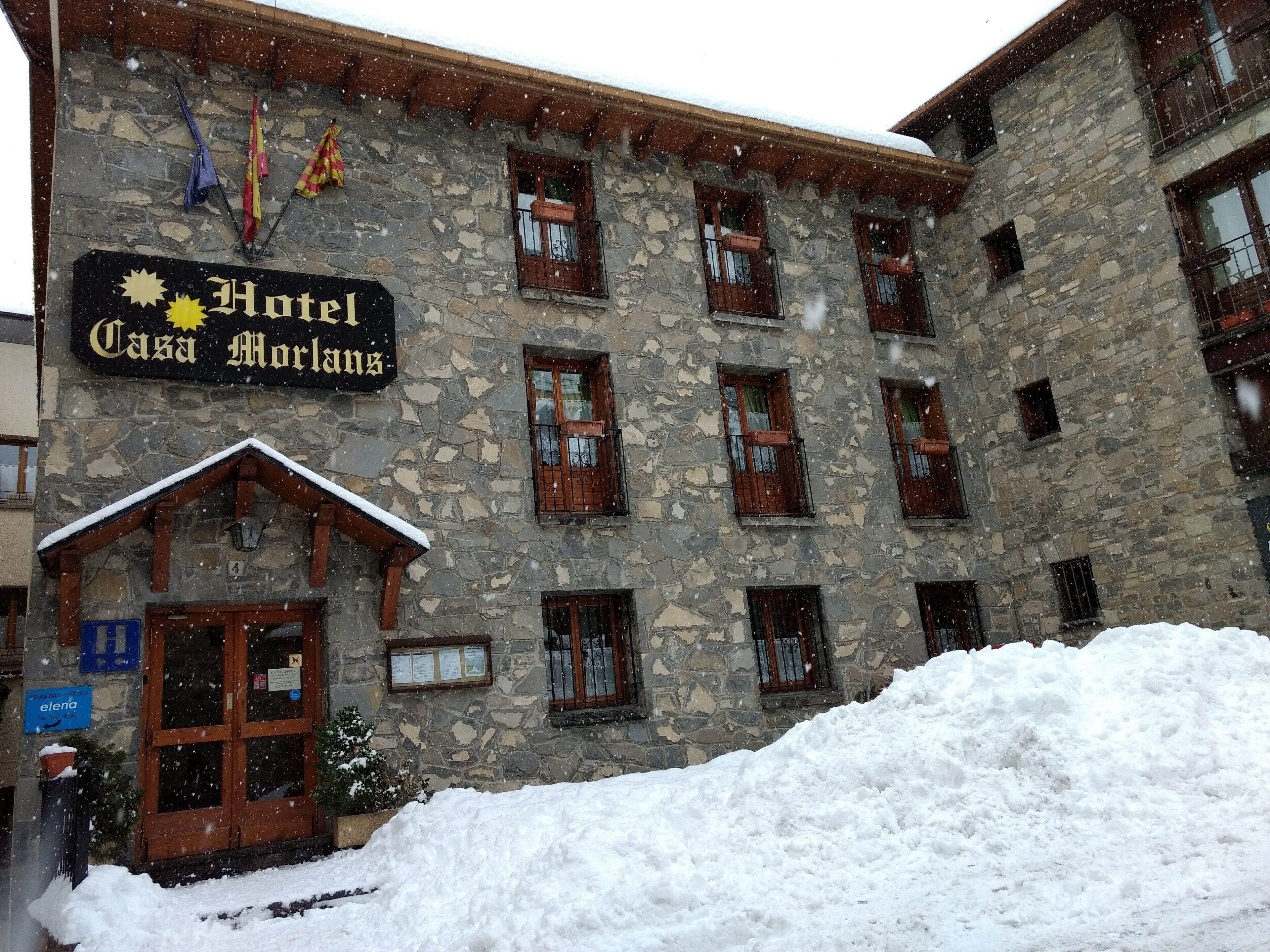 A stone building with a sign that reads "Hotel Casa Morlans."