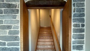 Una escalera con escalones de madera y paredes de piedra.