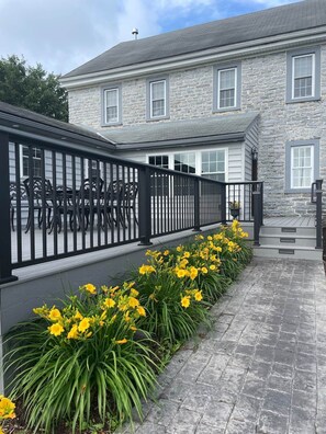 A stone building with a black metal fence and yellow flowers.