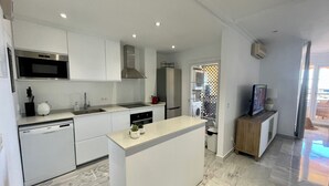 A modern kitchen with white cabinetry, a built-in microwave, and a dishwasher. - 2-bed Sea View Apt, 10 Mins From Puerto Banus (Marbella)
