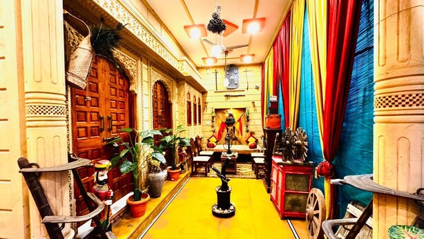 Una habitación tradicional con puertas de madera decoradas, suelo amarillo y cortinas coloridas.