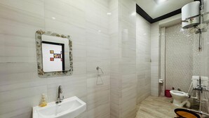 Un baño moderno con un lavabo blanco, un espejo y una zona de ducha.