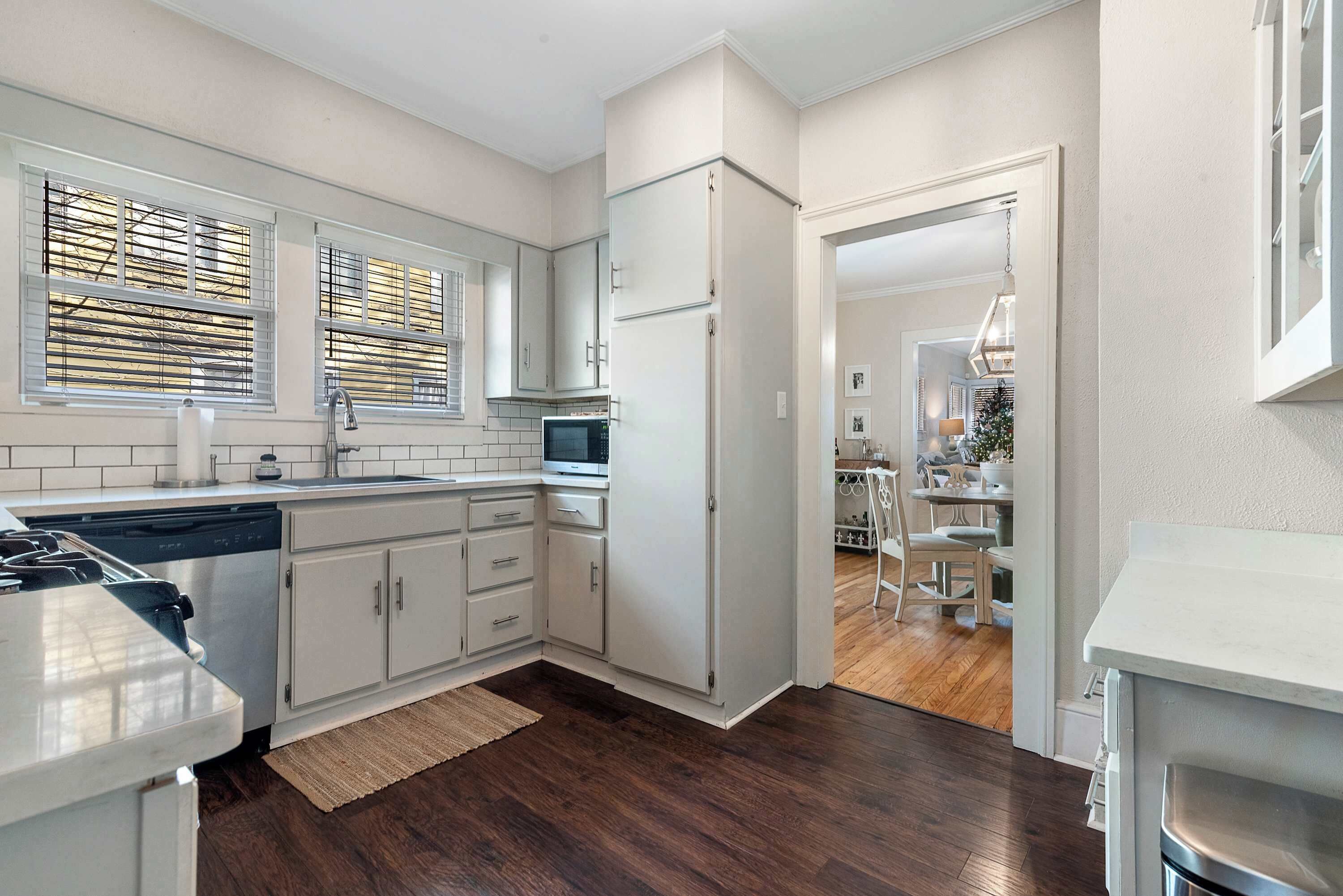 A modern kitchen with white cabinetry, a dishwasher, a microwave, and a refrigerator.