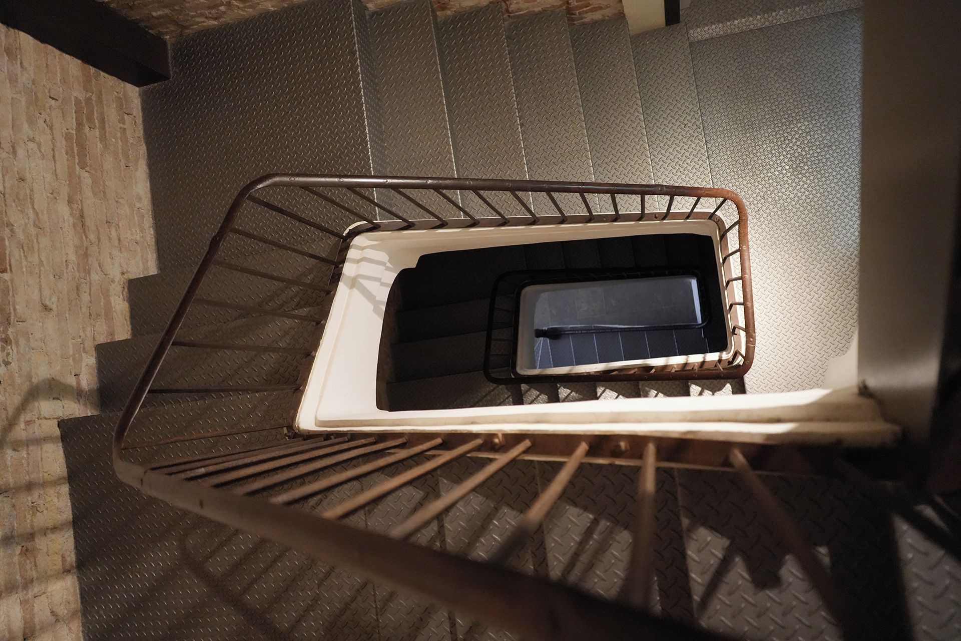 Un escalier en métal, doté d’une rampe en métal et d’un garde-corps en métal au sommet.
