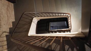 Un escalier en métal, doté d’une rampe en métal et d’un garde-corps en métal au sommet.