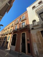 Un edificio a più piani con balconi, ampie finestre e affaccio sulla strada.