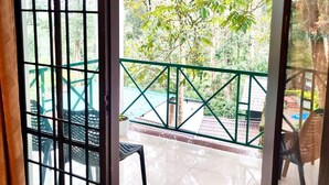 A balcony with a view of a garden and a pool. - Ayur Mount Resort & Spa (Udumbanchola)