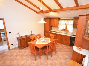 Enjoy meals in this cozy kitchen with a dining table and chairs, sink, and ample counter space.