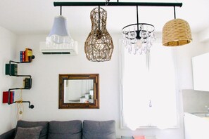 A living room with a sofa, a mirror, and three hanging lights. - Casa Macri, apartment in Santa Maria Novella (Firenze)