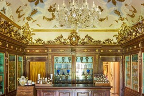 An ornate room with a chandelier, glass display cabinets, and a wooden cabinet. - Casa Macri, apartment in Santa Maria Novella (Firenze)