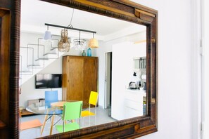 Un intérieur moderne comprenant un coin repas, un escalier et une cuisine.