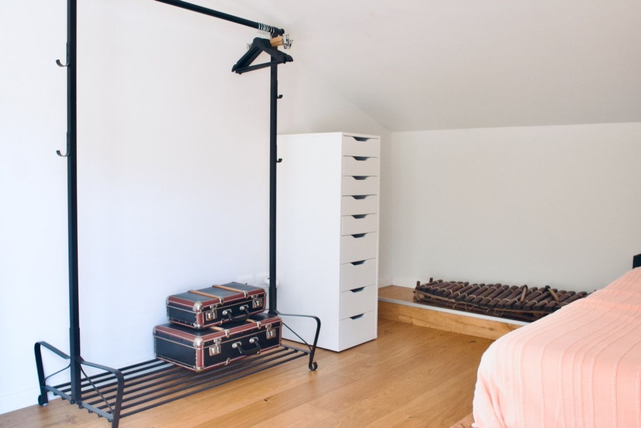 Une chambre à coucher comprenant un lit, une armoire, un radiateur et un porte-bagages.