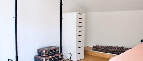 Une chambre à coucher comprenant un lit, une armoire, un radiateur et un porte-bagages.