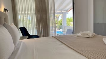 Habitación de hotel con una cama grande, una silla y vista a una piscina.