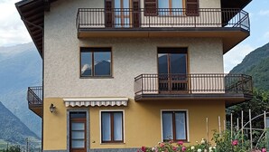 A two-story building with balconies, a door, and windows.
