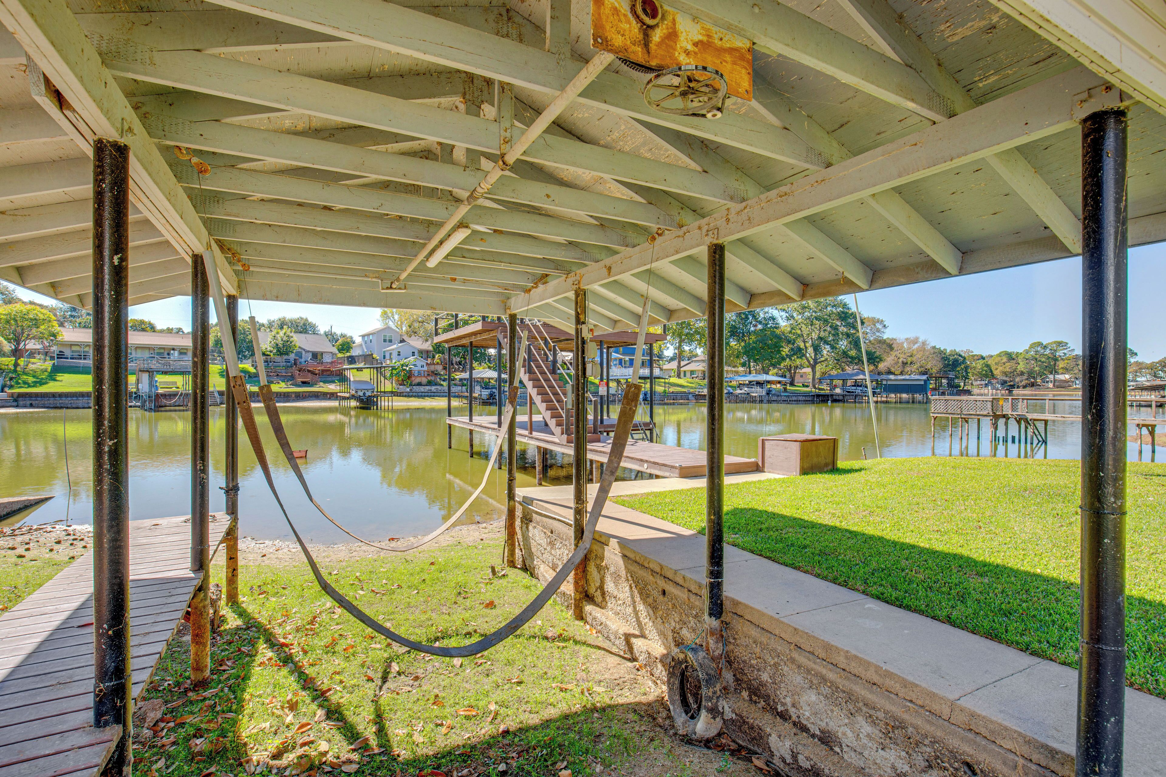 A covered outdoor area with a concrete floor, metal beams, and a hose.