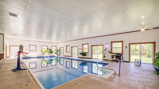 En inomhuspool med fri sikt över poolen, fönstren och taket.