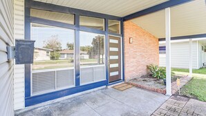 A house with a covered porch, a brick exterior, and a large sliding glass door. - 5 Mi to Texas City Dike & Beach! Family Hideaway (Texas City)