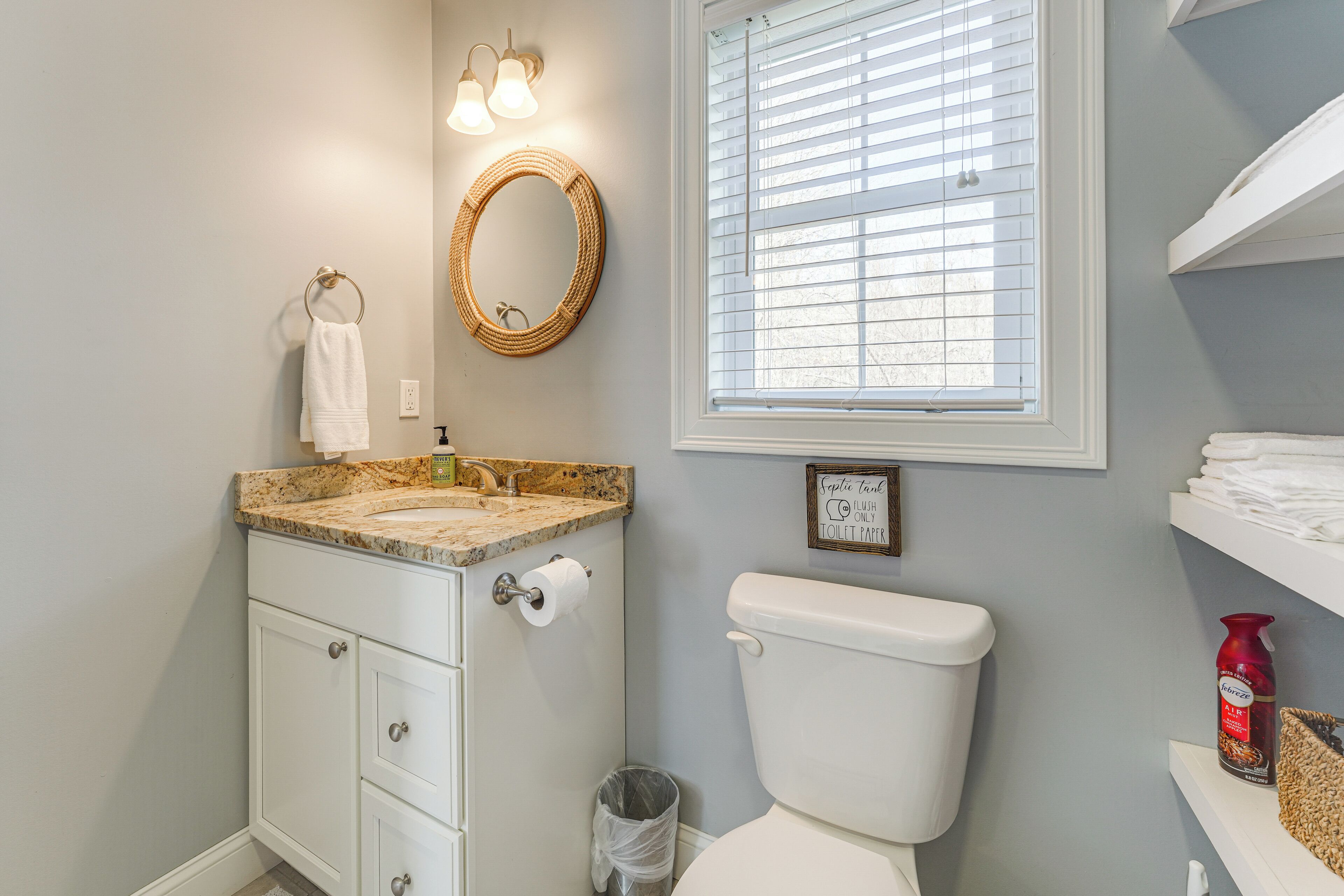 A bathroom with a toilet, sink, and mirror.