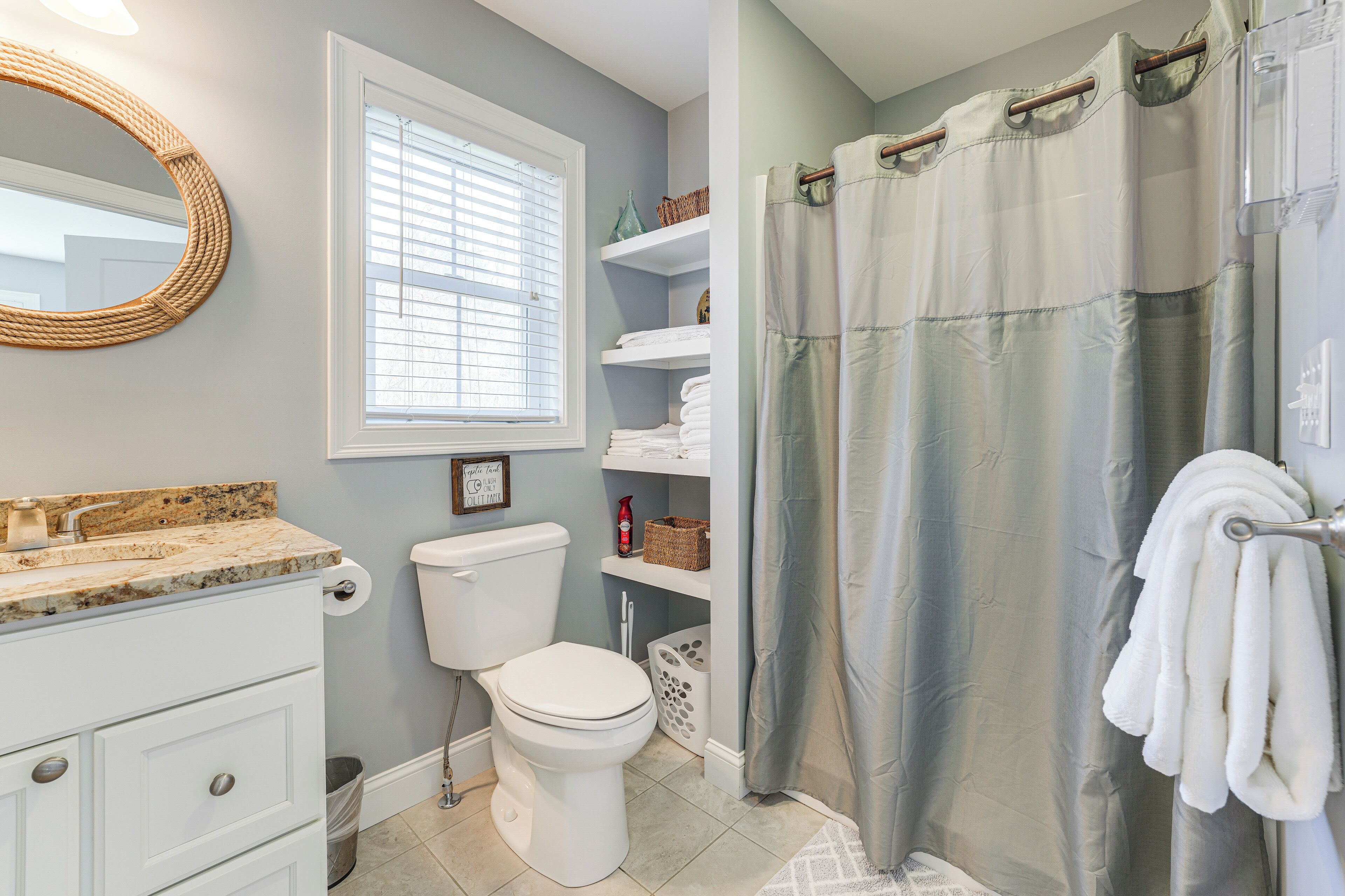 A bathroom with a toilet, sink, and shower curtain.