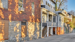 A row of townhouses with brick and stone facades, a central staircase, and a clear sky. - NYC Area Apartment on Hudson River! (Hastings-On-Hudson)