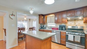 Una cocina con armarios de madera, estufa de acero inoxidable y una isla grande.
