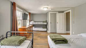 A room with bunk beds, a wooden dresser, a television, and a door leading to another room. - 5 Mi to Lake Ontario: Mexico Home w/ Seasonal Pool (Mexico)