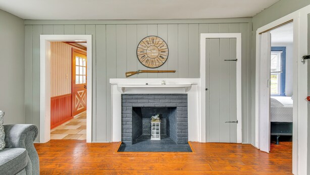 A room with a fireplace, a clock, and a door leading to another room. - 5 Mi to Lake Ontario: Mexico Home w/ Seasonal Pool (Mexico)