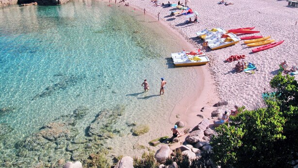 A beach with clear water, kayaks, and people. - Residence with pool in Costa Paradiso (Trinità d'Agultu e Vignola)