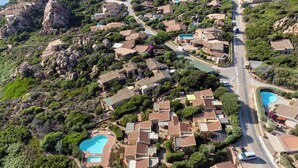 An aerial view of a residential area with houses, a main road, and a swimming pool. - Residence with pool in Costa Paradiso (Trinità d'Agultu e Vignola)