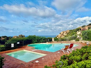 Una piscina al aire libre de temporada, sombrillas