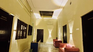Um hall de hotel com piso de mármore, balcão de recepção e áreas de estar.