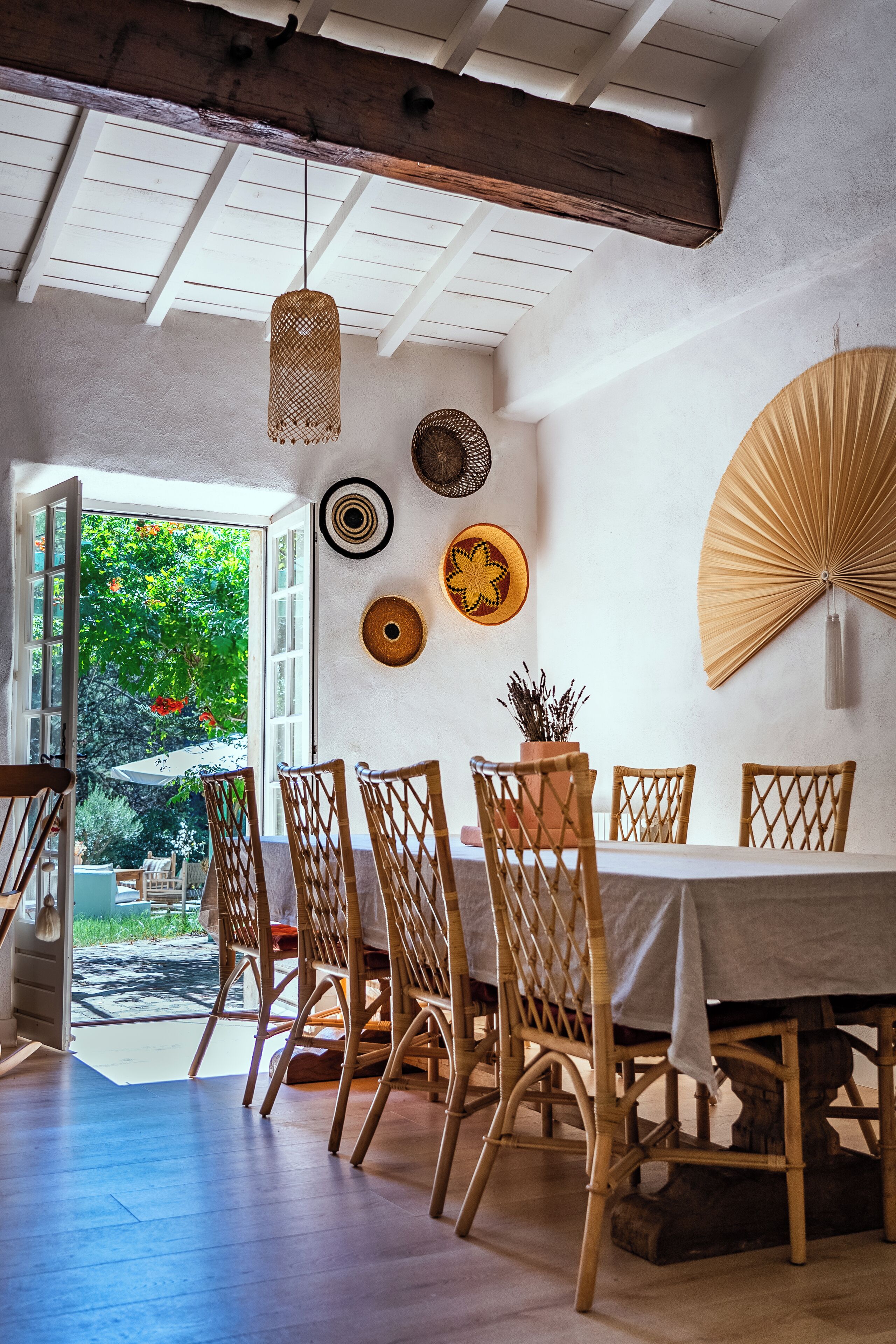 Un coin repas avec une table, des chaises et un ventilateur fixé au mur.