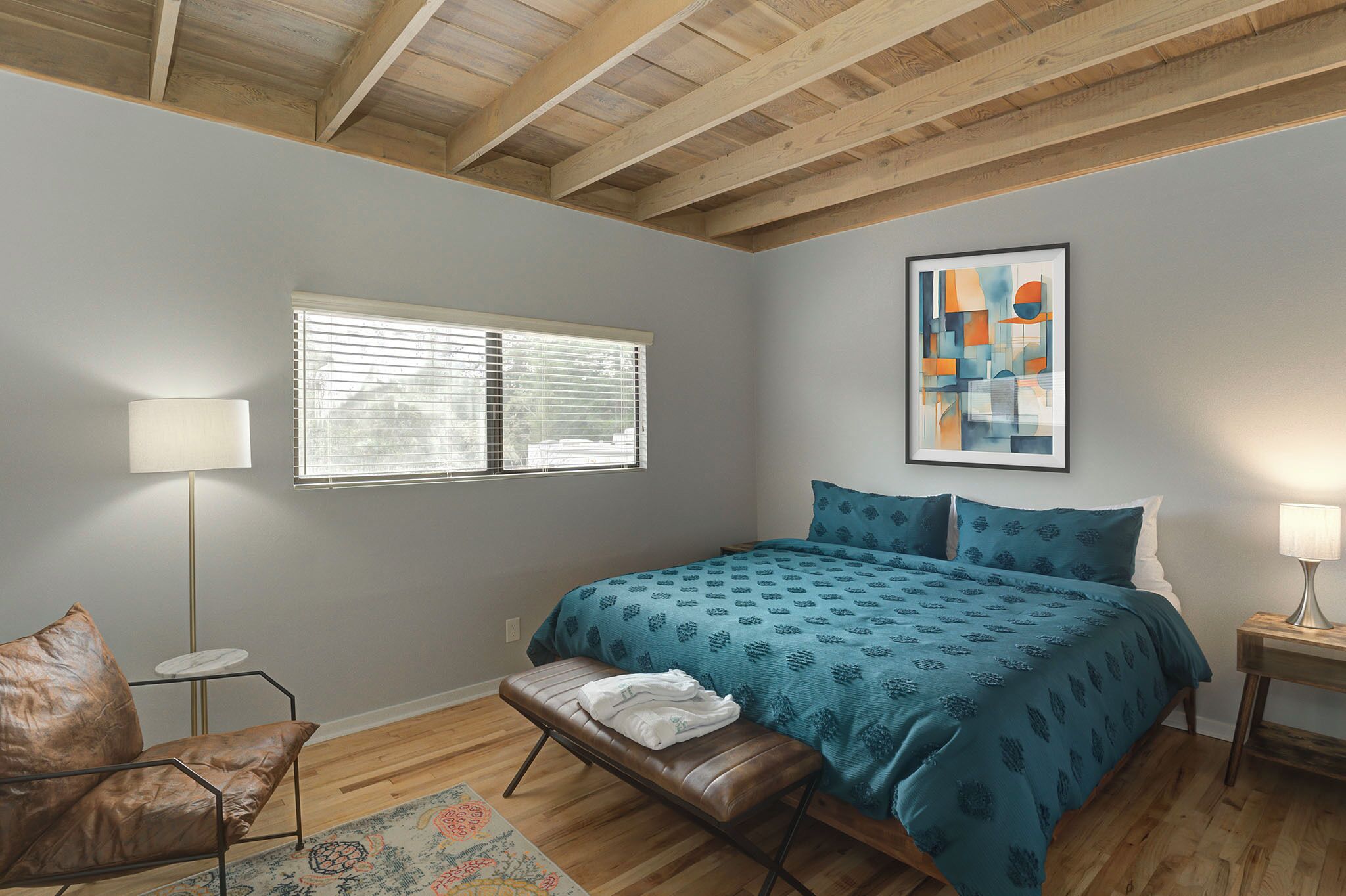 A bedroom with a bed, a bench, a chair, a window, and a painting on the wall.