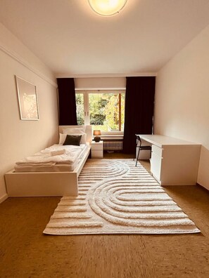 Ein modernes Schlafzimmer mit Bett, Nachttisch und Schreibtisch.