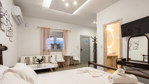 Een hotelkamer met een bed, een bank, een tafeltje en een televisie.