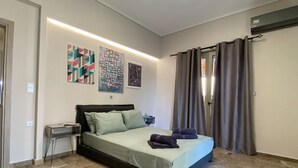 A bedroom with a bed, a nightstand, a wall-mounted air conditioner, and a window with curtains. - Kalamata Garden Haven - Escape Amidst Greenery (Kalamata)
