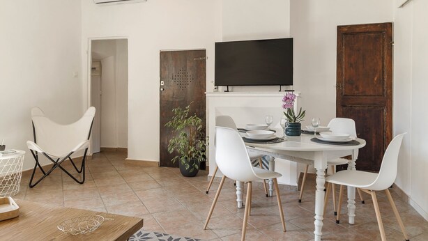Un coin repas avec une table blanche, des chaises et une plante en pot.