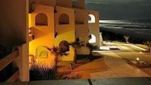 A building with a courtyard, under a night sky with a visible moon. - Beachfront Paradise Villa #23 (Playa Encanto)