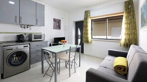 A compact living space with a kitchenette, a dining area, and a sofa. - T1-Sunset Apartment (Nazaré)