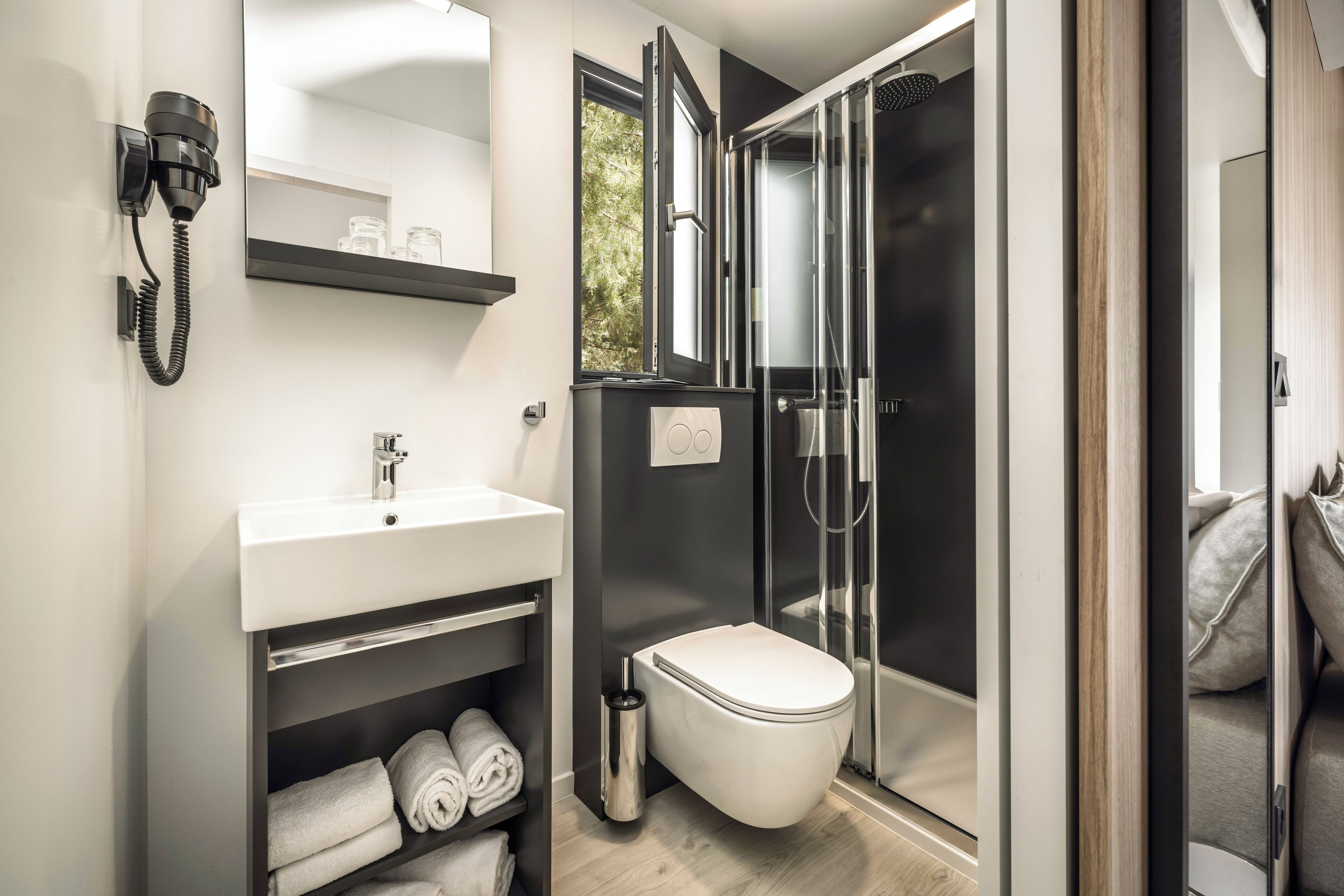 Ein modernes Badezimmer mit Toilette, Waschbecken und Dusche.