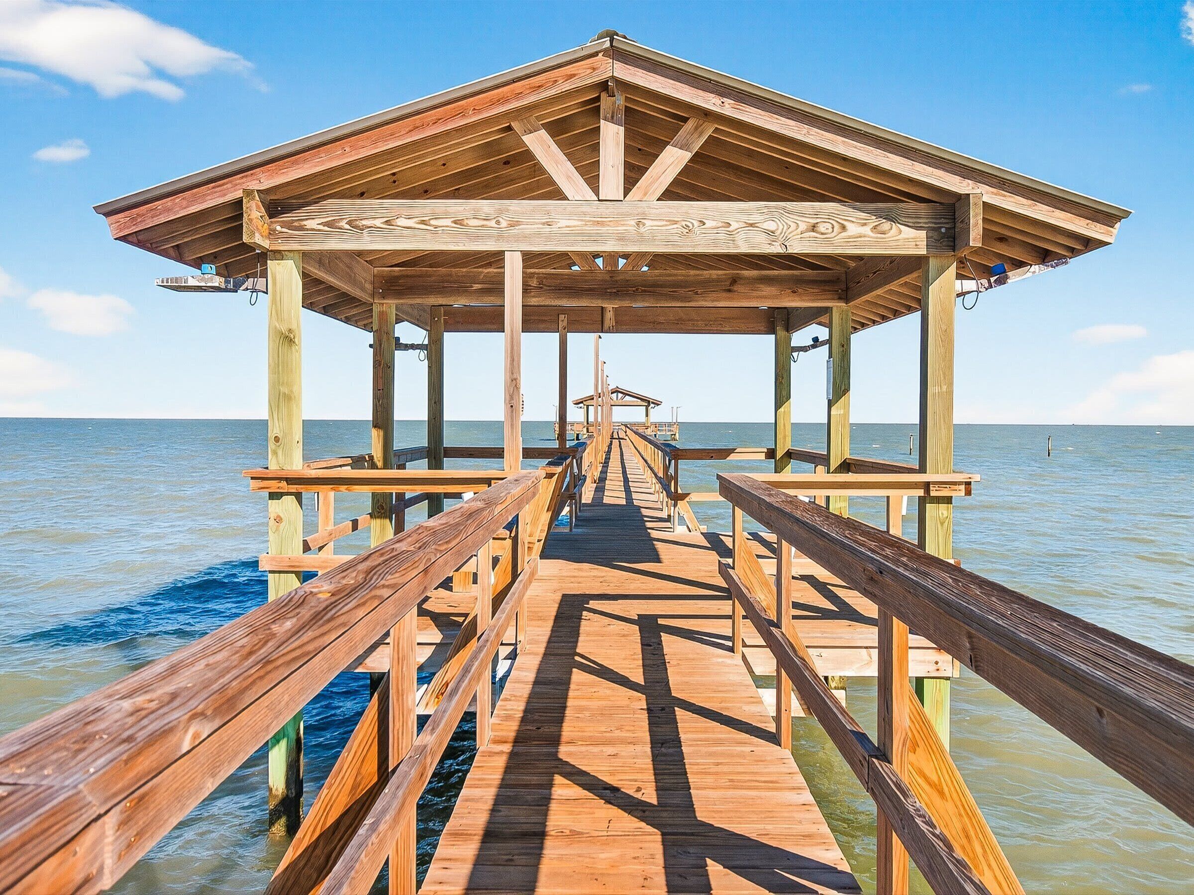 A wooden pier leading to a gazebo structure with a clear view of the water.